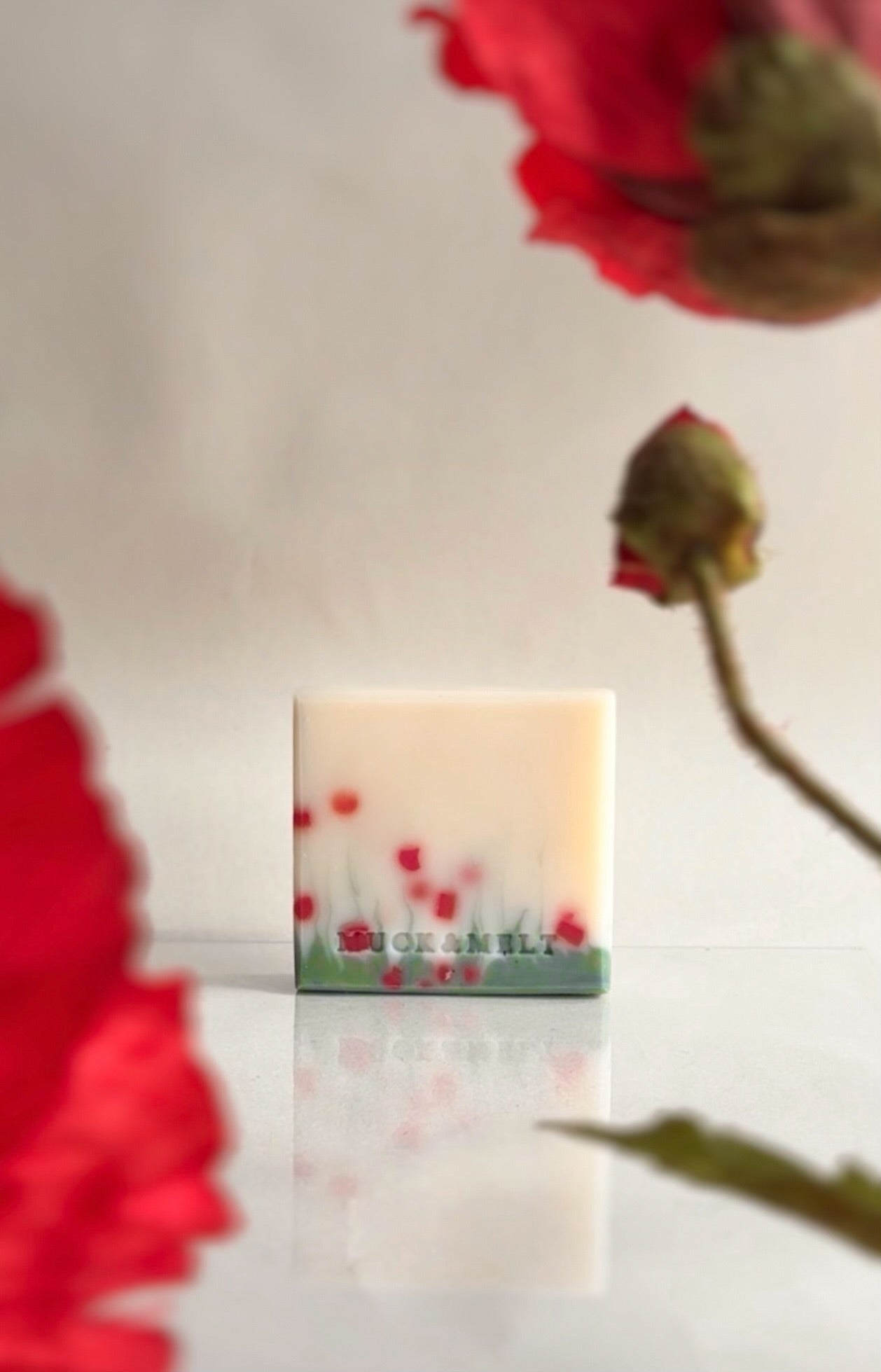Handmade natural poppy soap design featuring vibrant red poppies