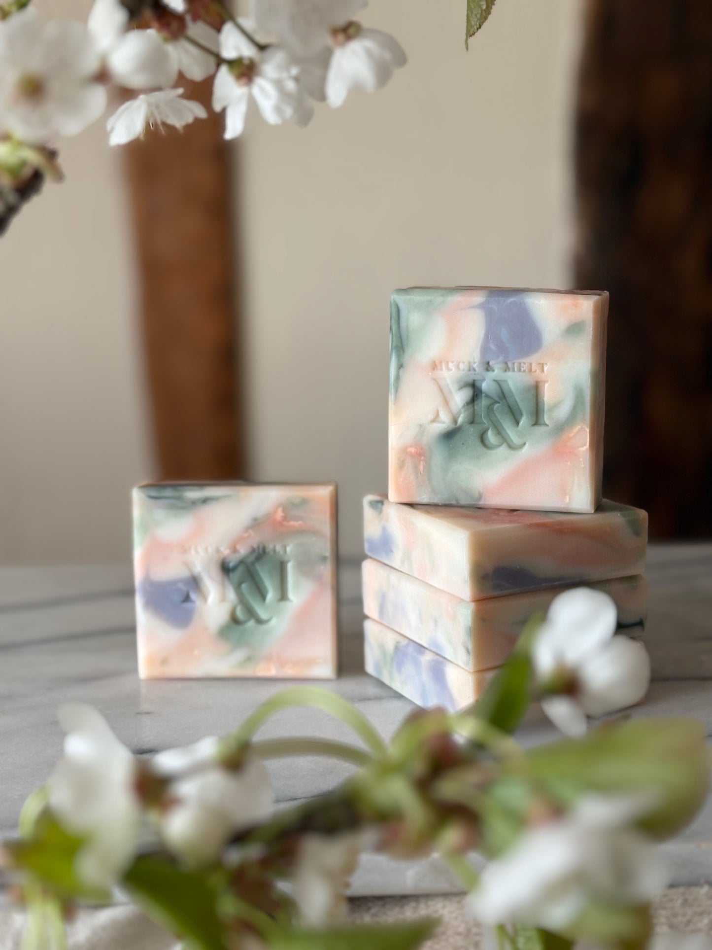 collection of natural Artisan soap bar with floral-inspired swirls in natural pink, green, lilac and white hues with blossom branches
