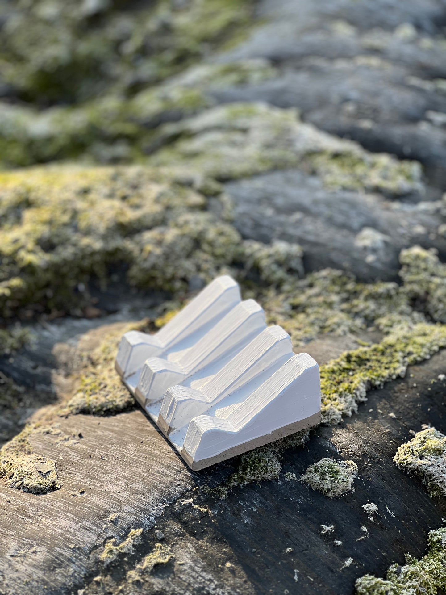 Organic-shaped soap dish with natural clay texture and rustic feel on beach