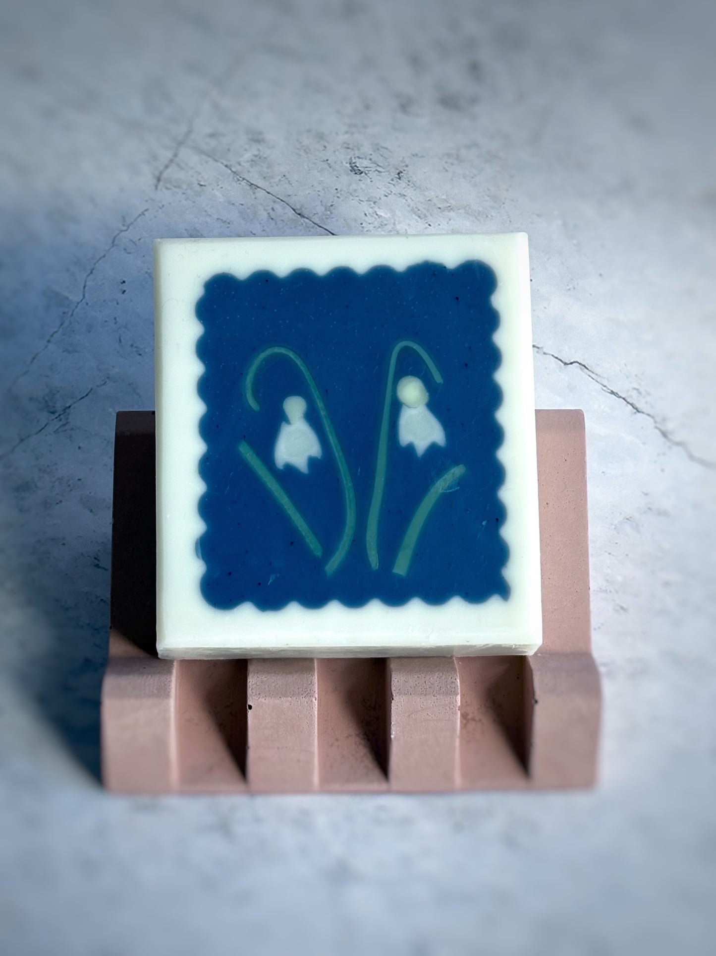 Artisan soap with snowdrop flower motifs on terracotta coloured soap dish
